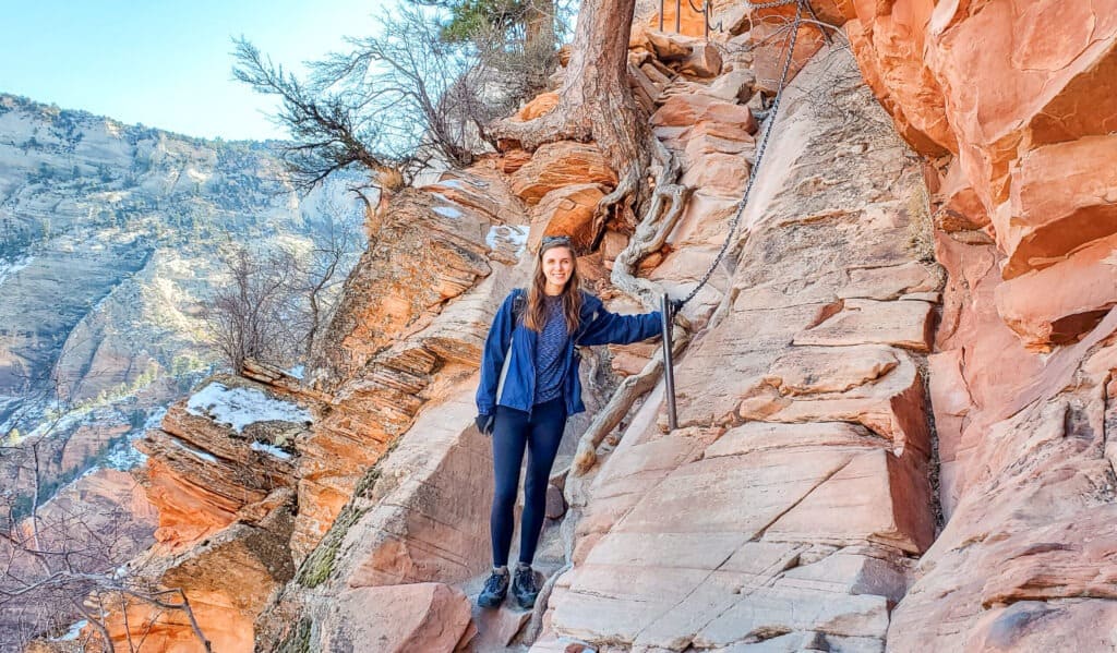 A woman holds onto a large chain to help people leading up the slick rock.