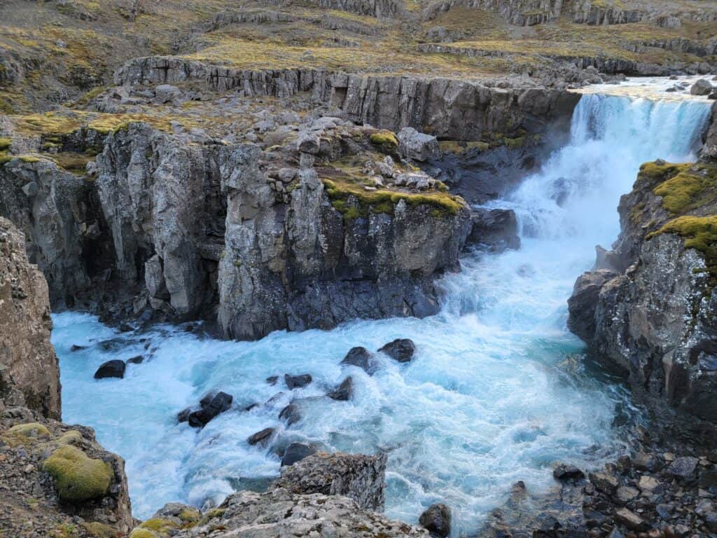 A rocky face with white water crashing down the rocks.