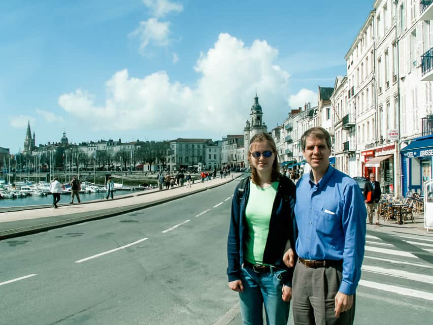 A father and daughter stand on a street in La Rochelle, France.