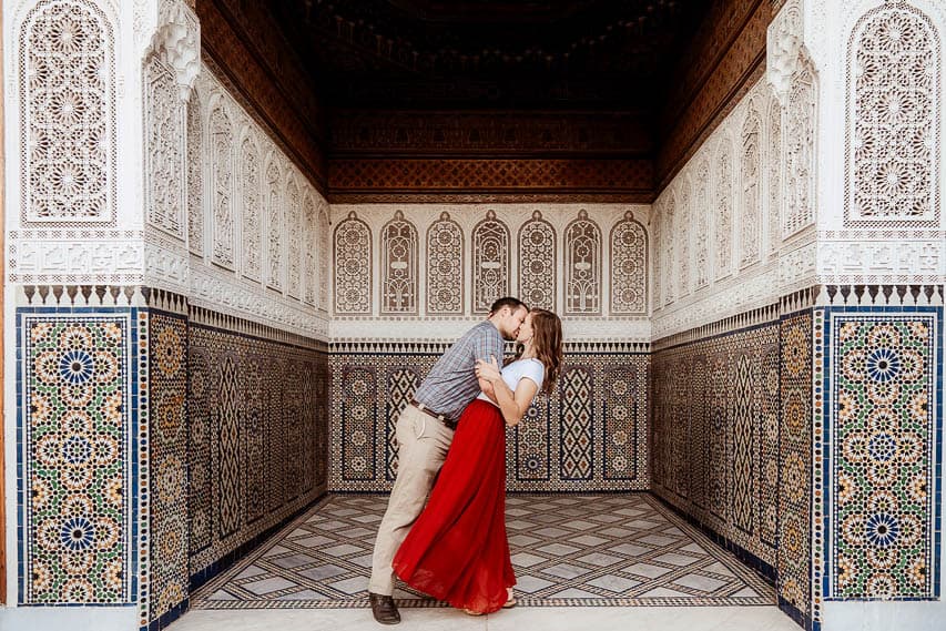 An intricately carved alcove in the Musee dar el bacha. A man and a woman kiss in the middle of the alcove.