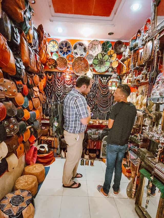Two men haggle good-naturedly haggle over the price fo a lamp in a little shop in the souks of Fes.