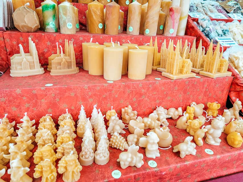 Beeswax candles in a variety of shapes and sizes on display at the market.