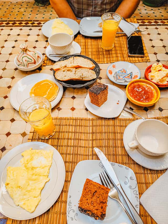 A classic Moroccan breakfast spread with eggs, bread, jellies, and a breakfast cake.