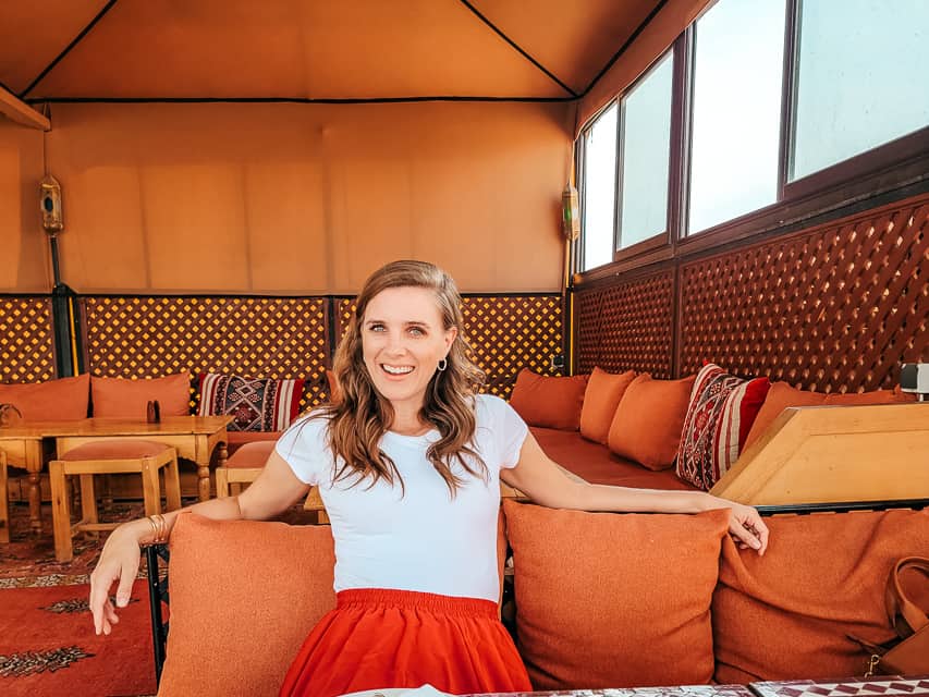 A woman lounges on a couch on the roof or a Moroccan restaurant.