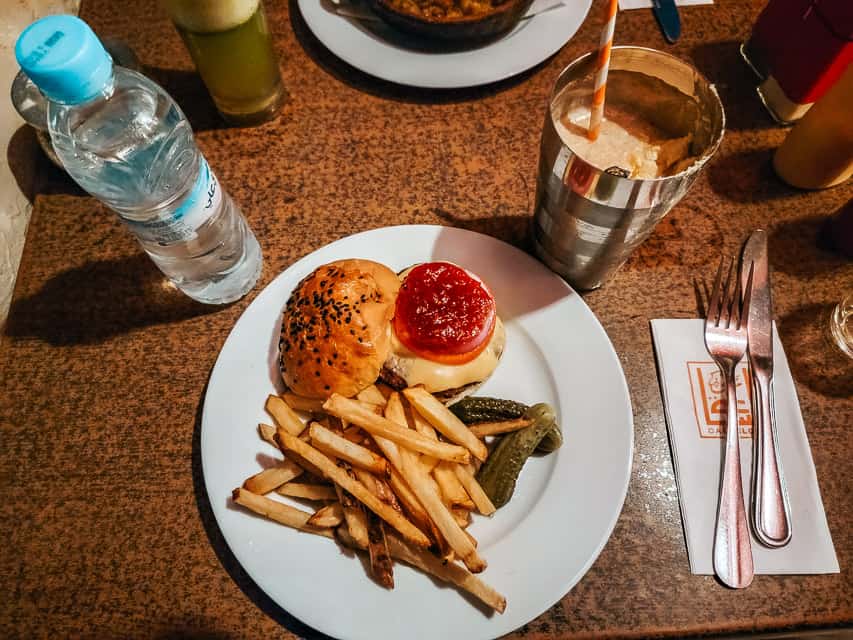 A must-try food in Morocco is a camel burger. Here the camel burger is served with fries, pickles, and a date shake.