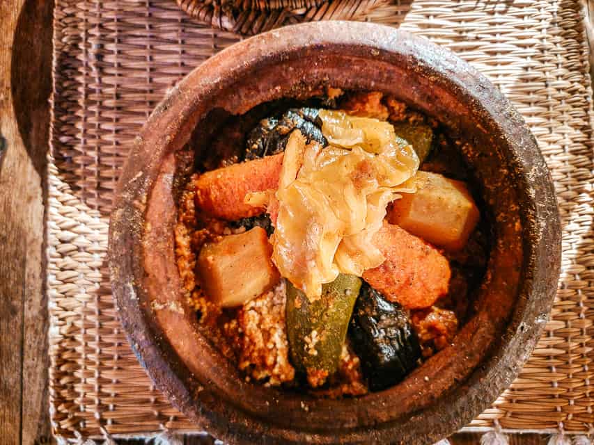 A small tagine dish filled with couscous and various vegetables.