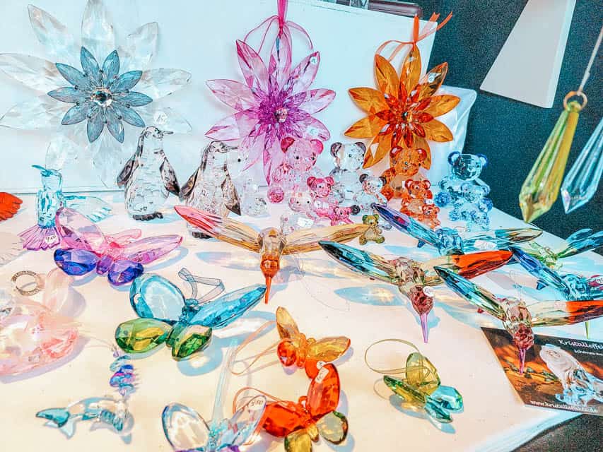 A stall selling colorful, delicate glass figurines at the market.