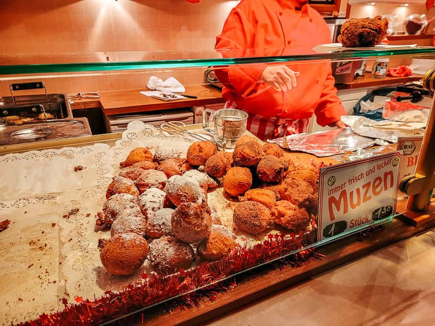 A stall selling muzen - fried balls of dough coated in powdered sugar.