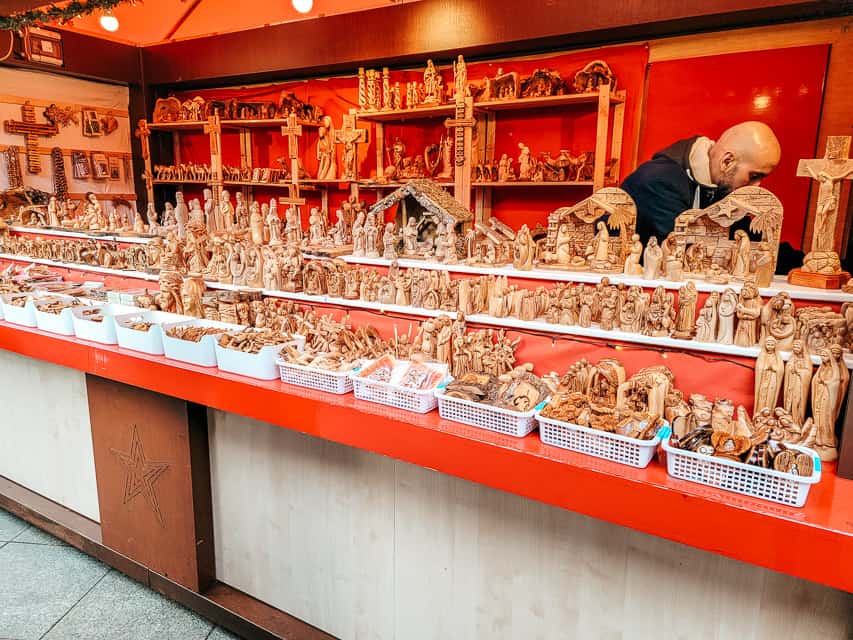 A red stall full of olive wood nativity pieces at the Cologne markets.