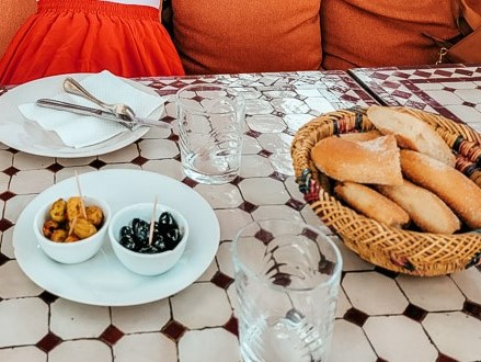 A basket of khobz - Moroccan flat bread - is served with small bowls of olives.