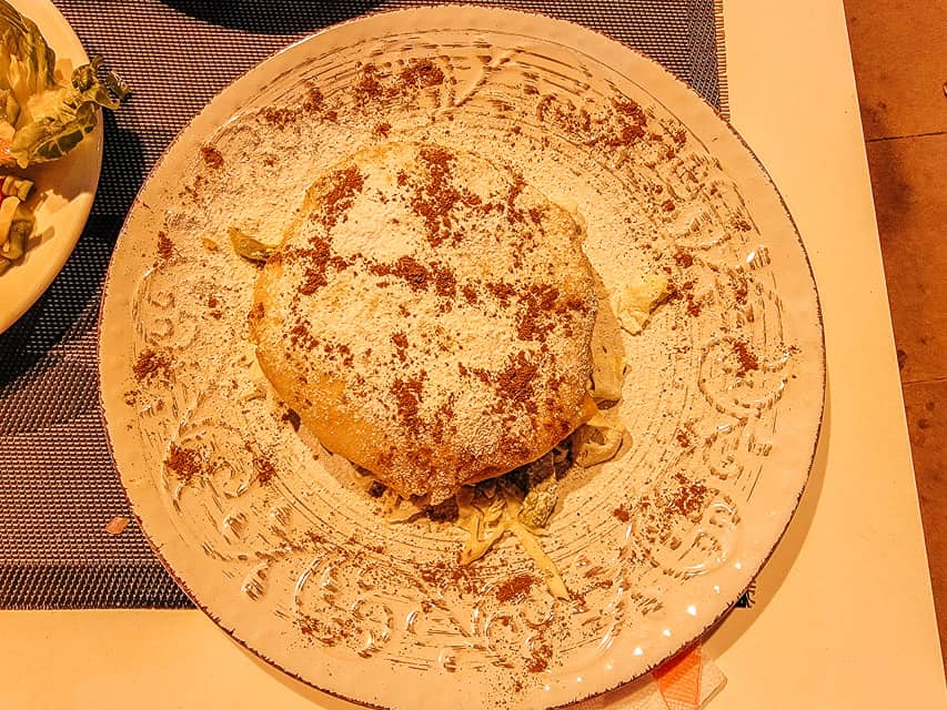 Pastilla is a Moroccan dessert that has a spiced meat in the center of dough topped with powdered sugar and cinnamon. A fun food to eat in Morocco.