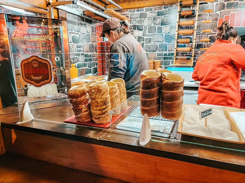 A market stall selling chimney cake - large rounded dough with a hollow interior.