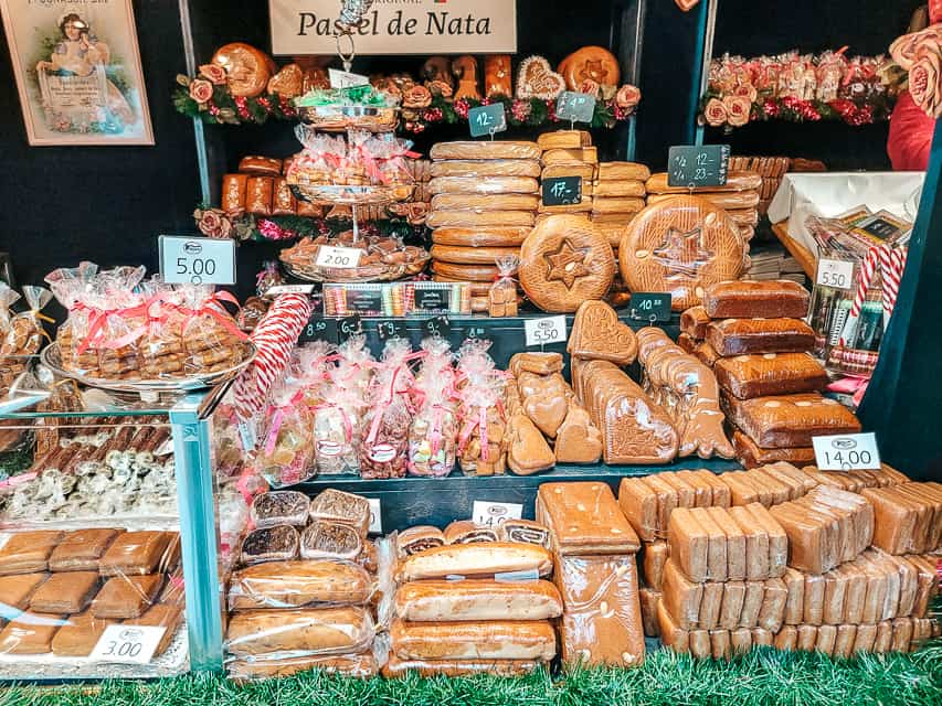 A market stall full of gingerbread and stollen, some in circles, some in squares, some in hearts, and some in loaves.