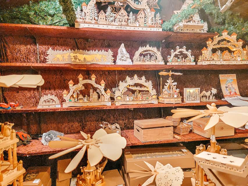 Shelves full of wooden boxes, wooden christmas pyramids, and wooden nativity scenes in the market.