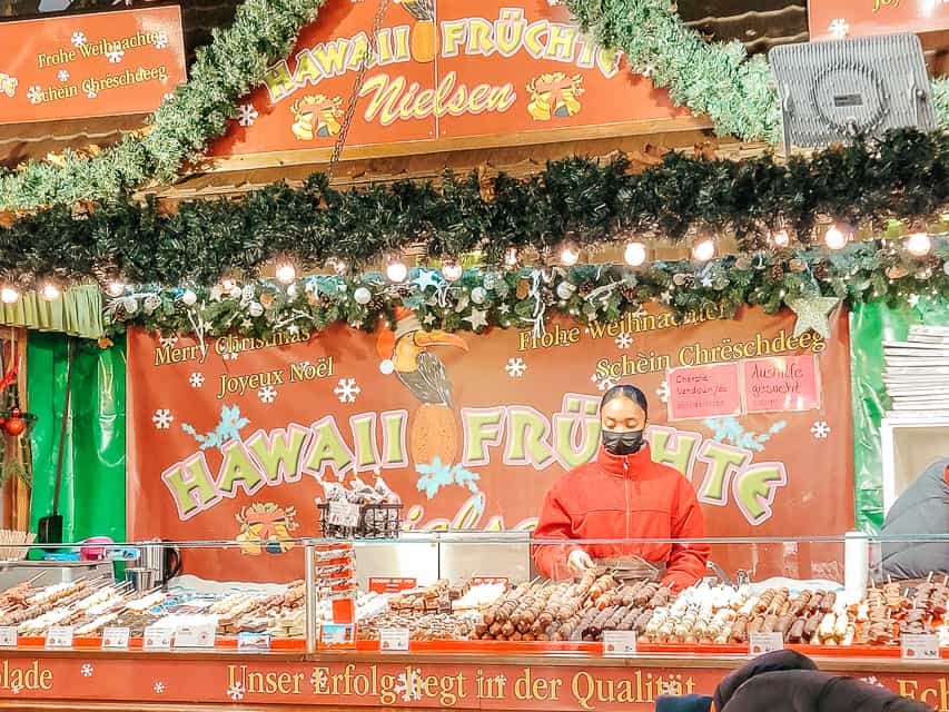 A stall selling Hawaiian snacks, including fruit on a stick.