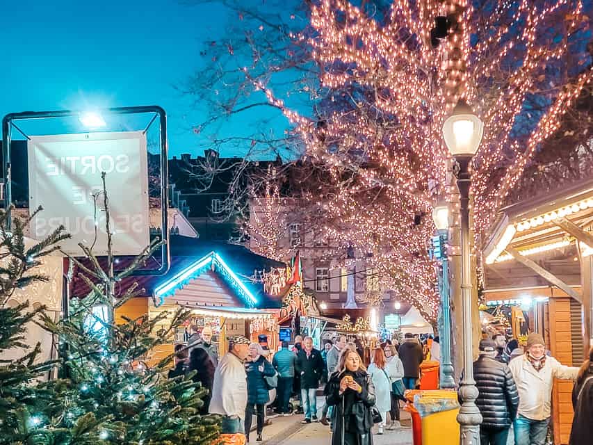 Lit trees and market stalls at the Place d'armes market in Luxembourg.