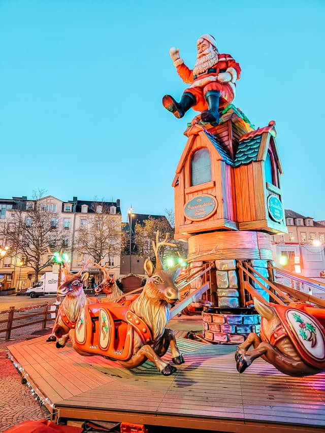 A christmas ride: Reindeer attached to wooden poles spin around a center, and you can sit in boxes on the reindeer. Santa is sitting on top of the middle.