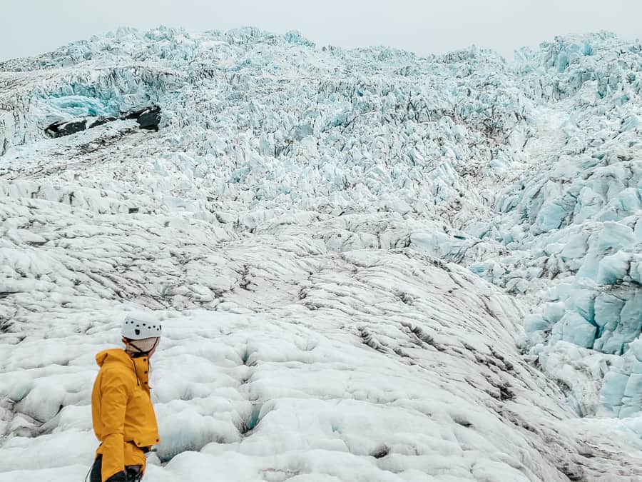 A woman in a yellow jacket on an Iceland Glacier. Falljokul Glacier.