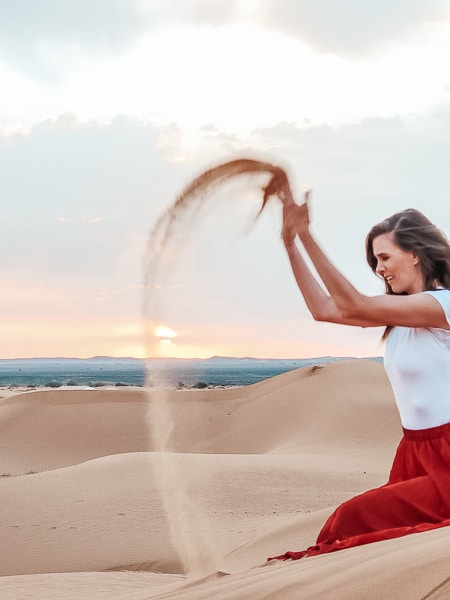 A beautiful woman fails to throw sand properly.
