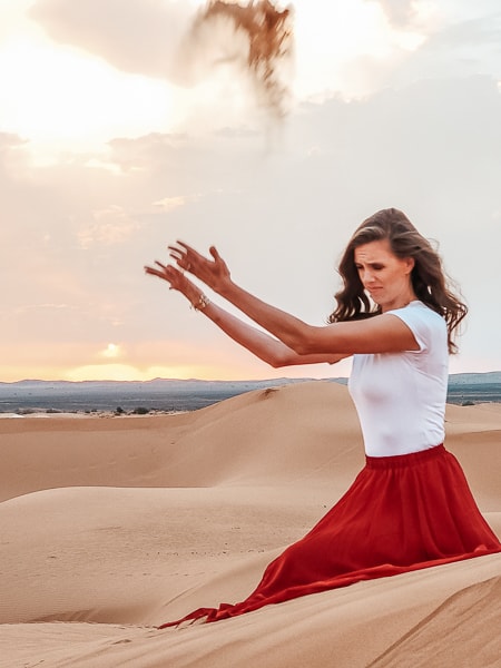 A woman in the desert at sunrise.