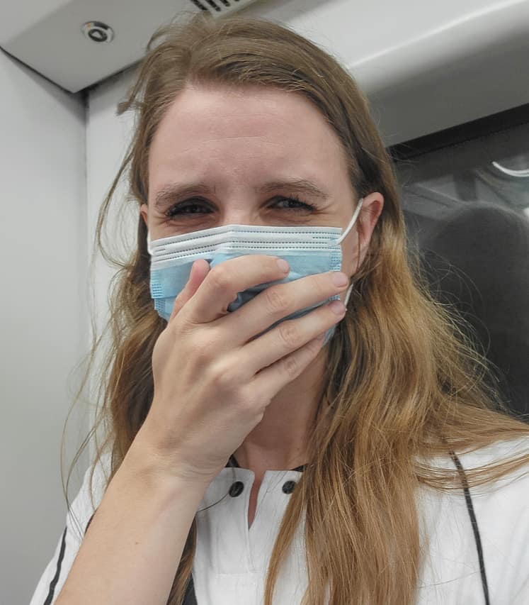 A woman uses a face mask to try and block tear gas.