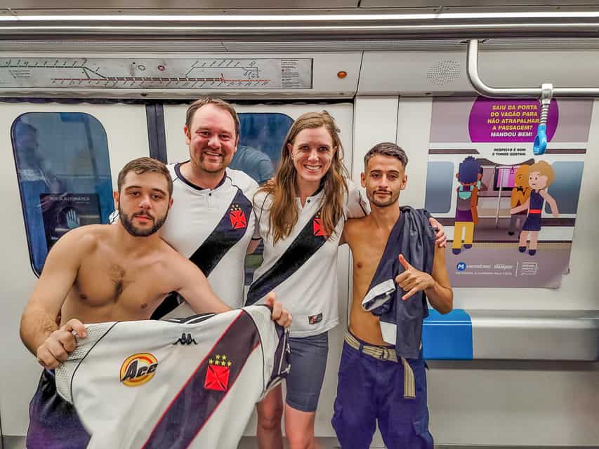 Four people in Vasco de Gama gear ride a metro.