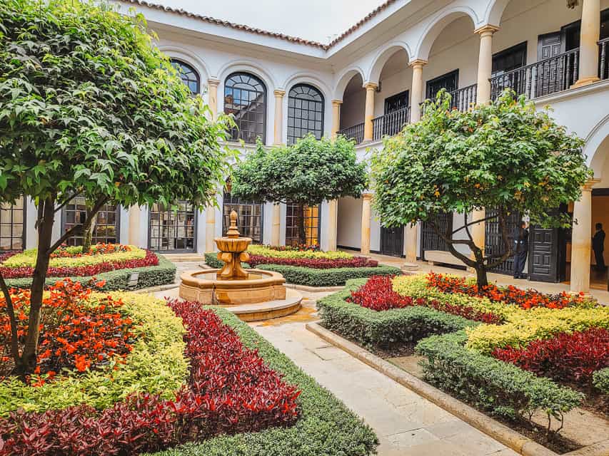 A colorful courtyard garden lined by an archway, in the Botero Museum in Bogota, Colombia.