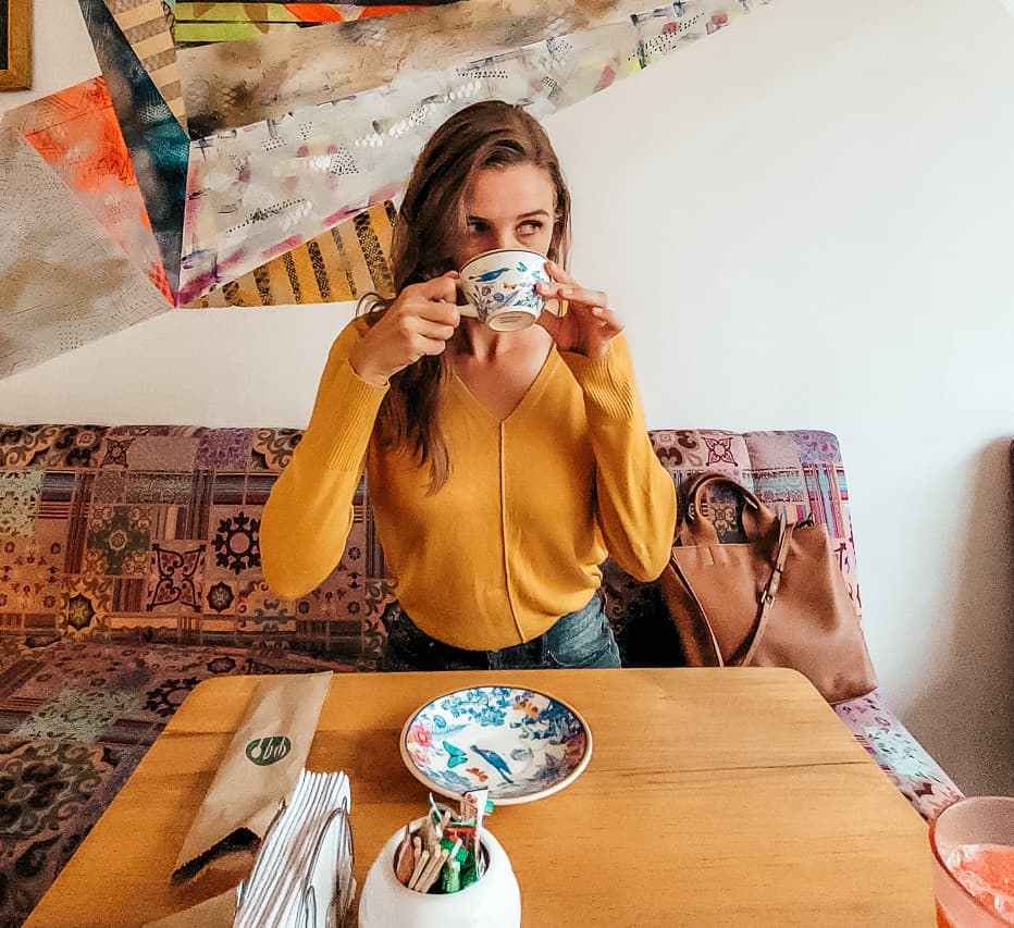 A pretty woman drinks hot chocolate in a Colombian cafe.