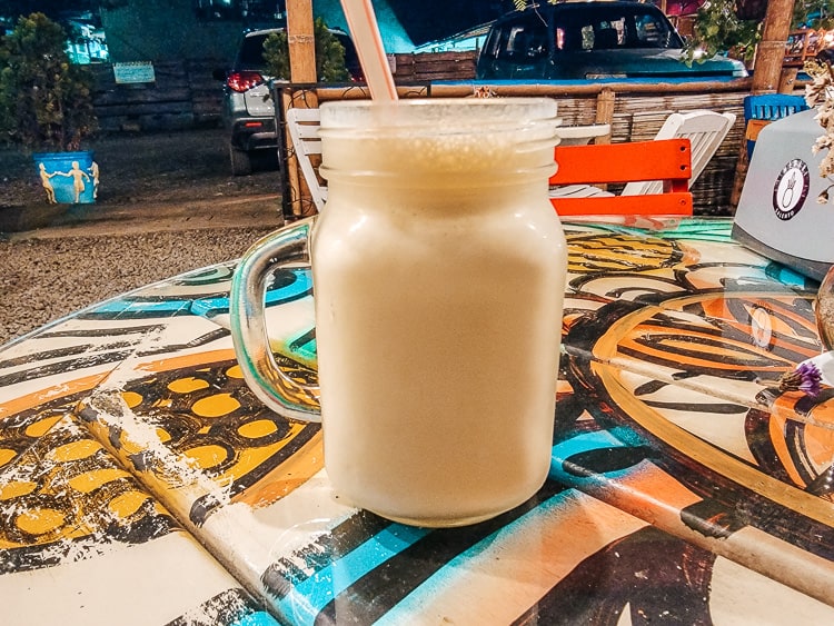A mason jar of jugo con leche. This delicious Colombian drink comes in a variety of flavors. It is juice mixed with milk.