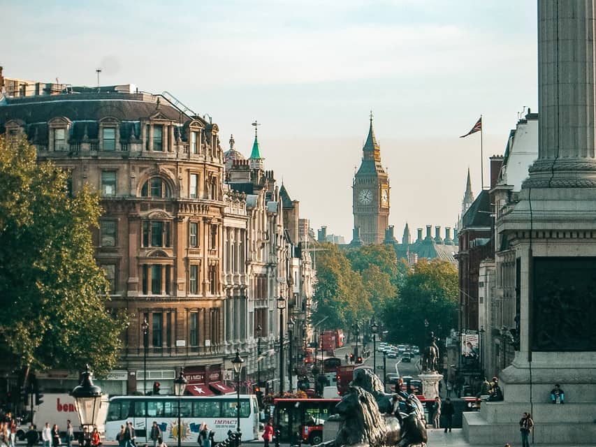 A view of London looking pasts statues of lions toward Big Ben.