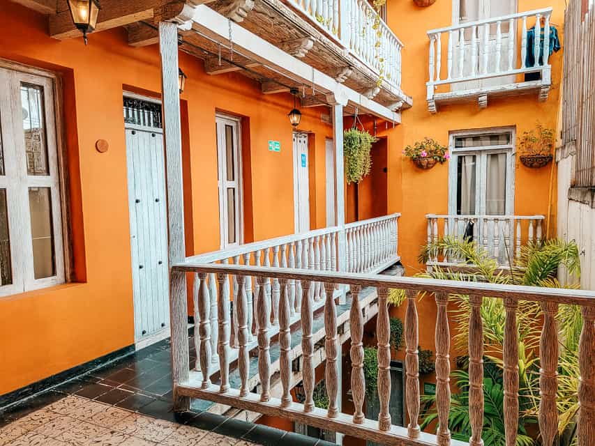 A view from the balcony of the inner courtyard of an orange hostel in Colombia.