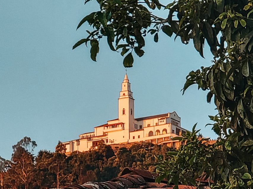 A zoomed in view of the white church of Monserrate, with grenery framing the shot.