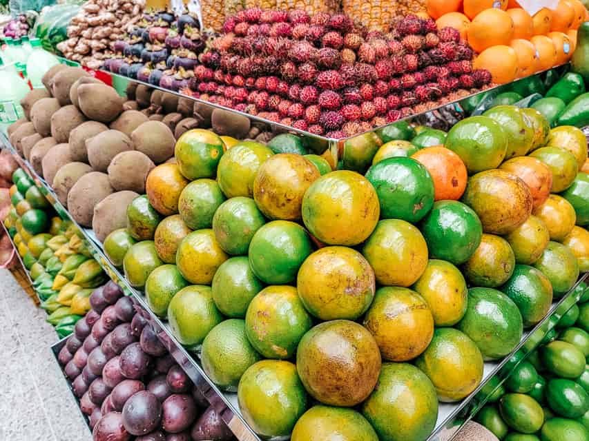 A stand in a fruit market with a large variety of colorful tropical fruits. Trying tropical fruits is a must do on your 3 day Bogota itinerary.