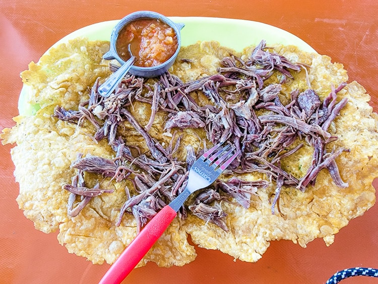 An extra large and thin patacone served with shredded beef.