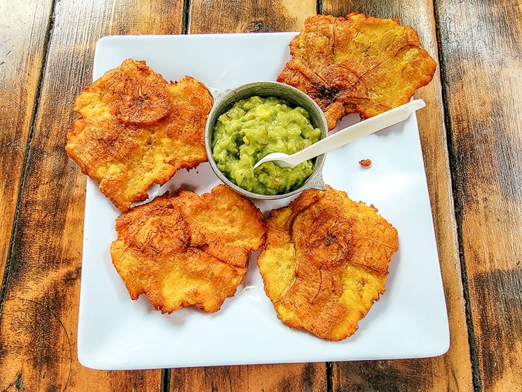 A plate of four patacones and with guacamole dip. A great food to eat in Colombia.