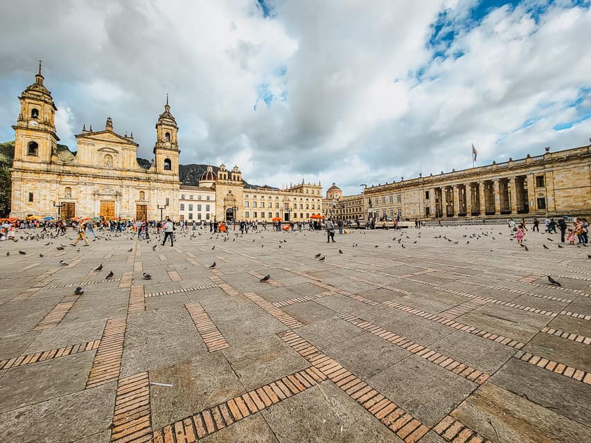 There is a large square with official government buildings and a church in the background. Everything is made of beige stone.