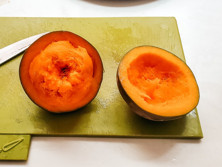 Sapote (zapote) fruit cut open. A brown skin and a bright orange interior.