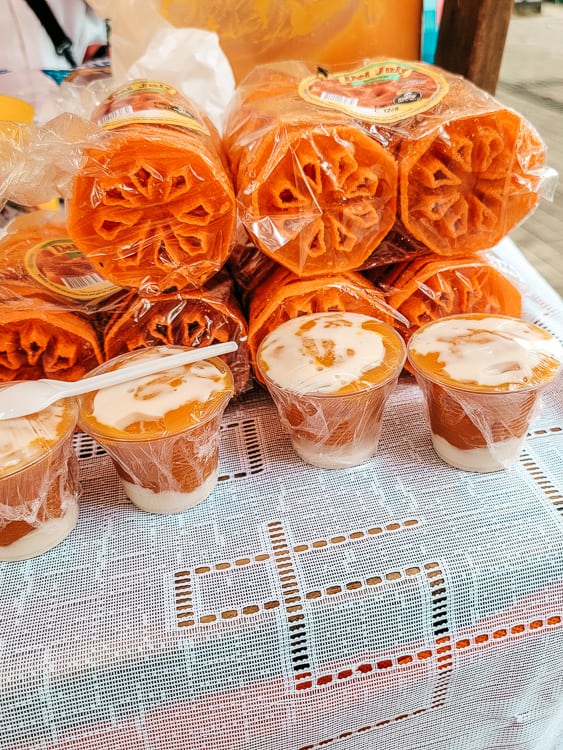 A package of solteritas for sale on a table with desserts in a cup in front.