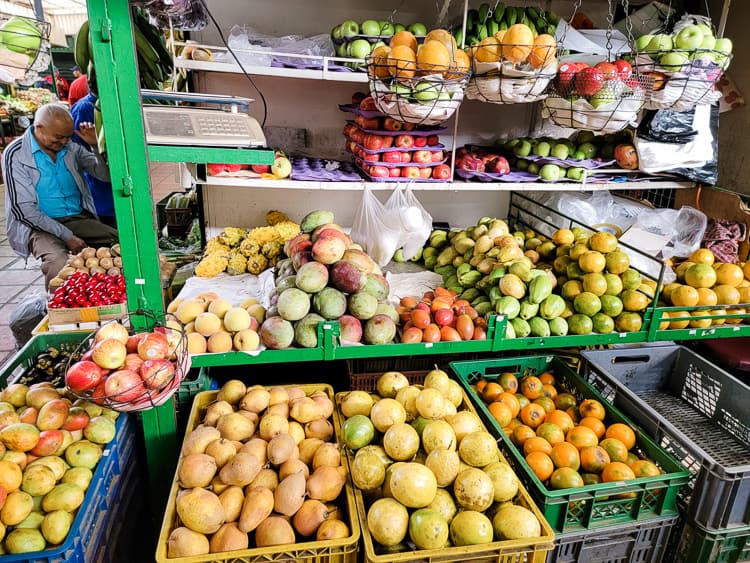 A market stand with different colored fruit in different baskets