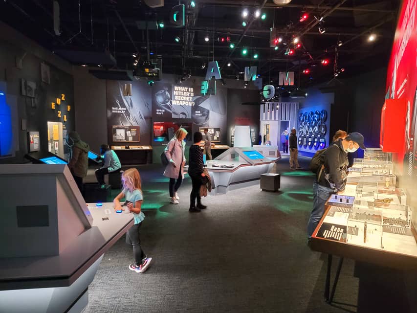 Several adults and children interact with displays at the Spy Museum in Washington, DC.
