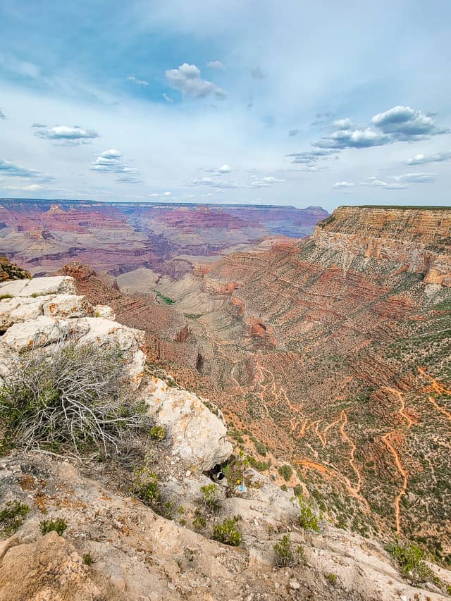 Looking into the Grand Canyon from Trail Overlook. Bright Angle Trail forms an orange, winding line down the side of the canyon toward the river below.
