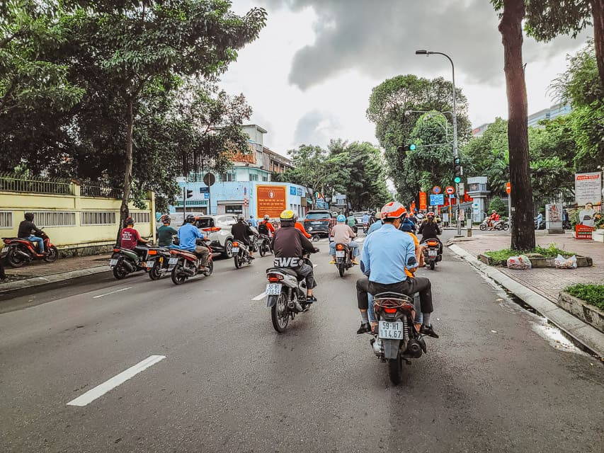 The street from the view of a motorcycle with lots of motorcycles taking up the streets of the city