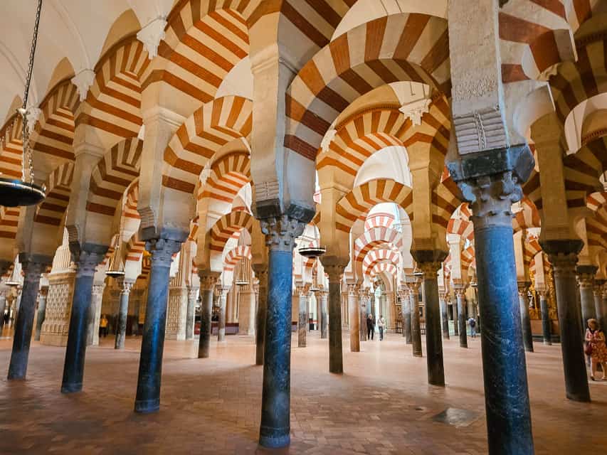 A big room with hundreds of granite pillars with red and white stripes.