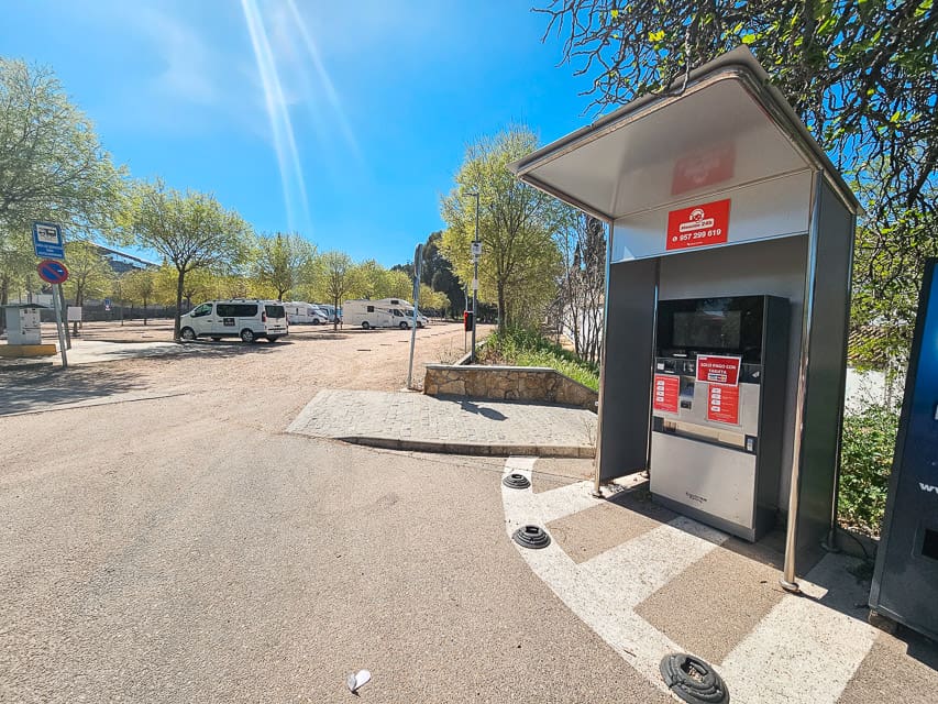 A gray and red pay station at a parking lot in Cordoba, Spain.