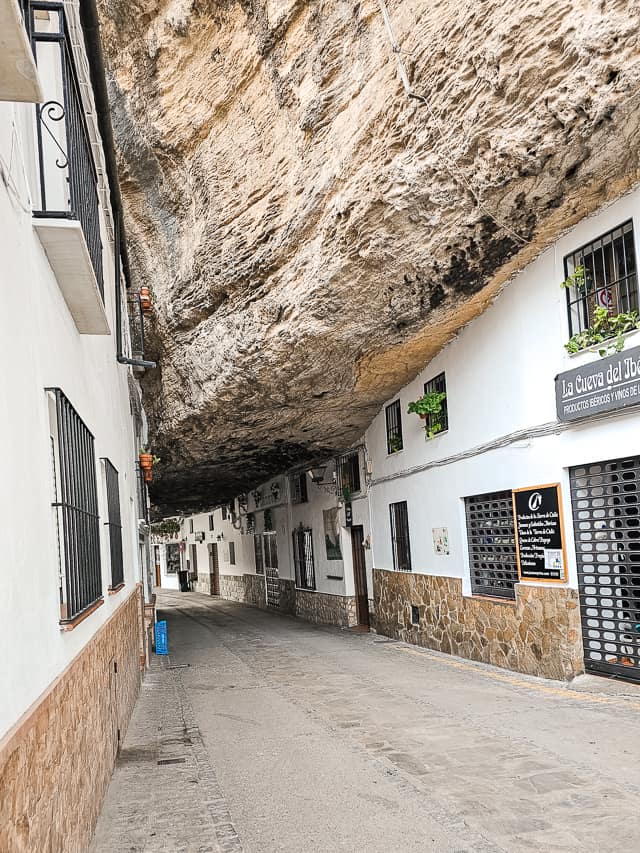 Calle Cuevas de la Sombra in Setenil is topped with a massive rock covering the street and buildings.