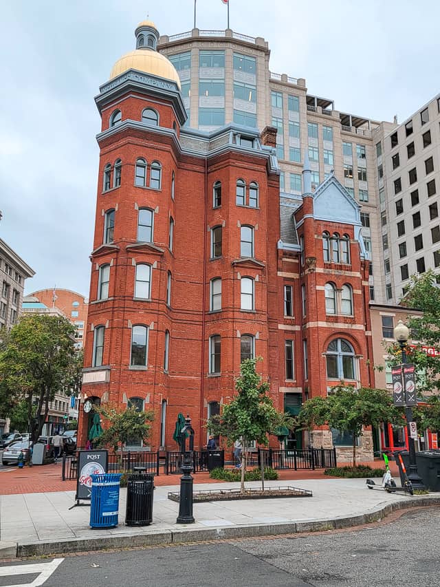 A red brick building in with a golden dome.