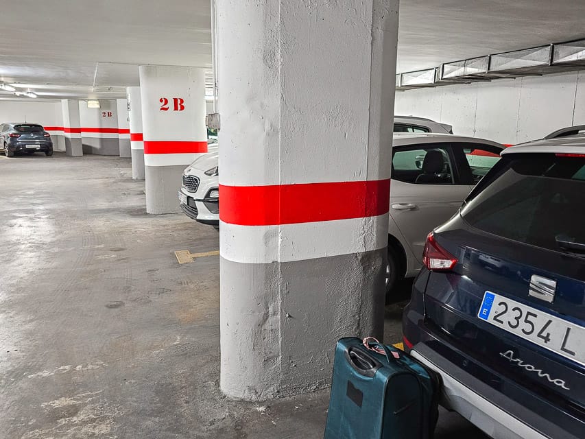 White, red, and gray pillars and walls of a parking garage in Seville, Spain.