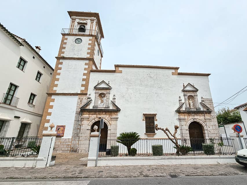 A white church with a white and tan tower in town.