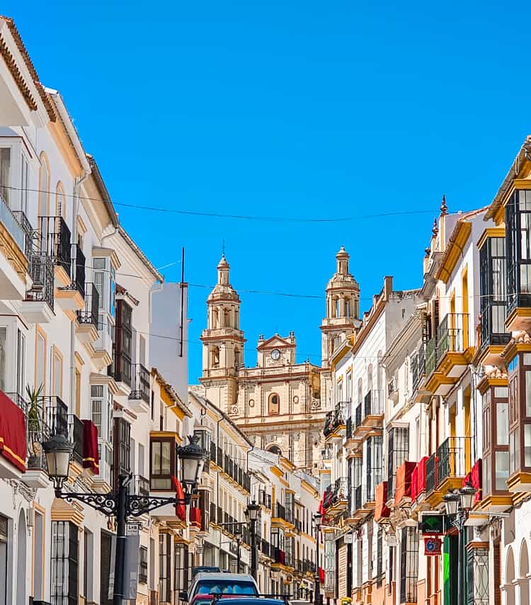 White buildings with a church behind.