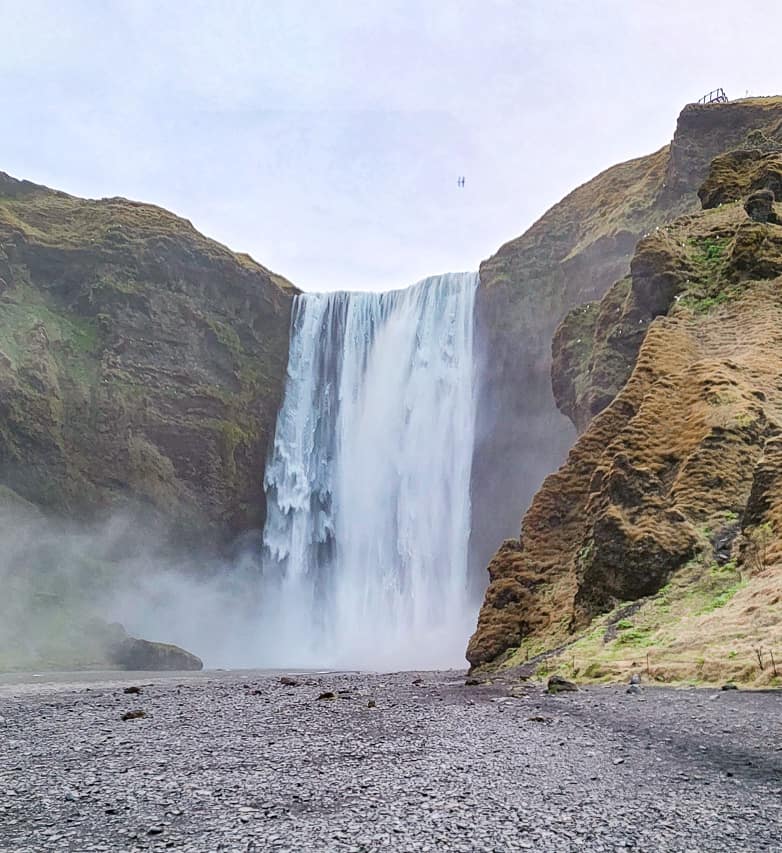 The giant Skógafoss crashes down over a cliff wall.